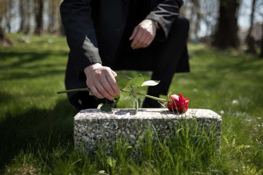 man-bringing-rose-tombstone-cemetery man-bringing-rose-tombstone-cemetery